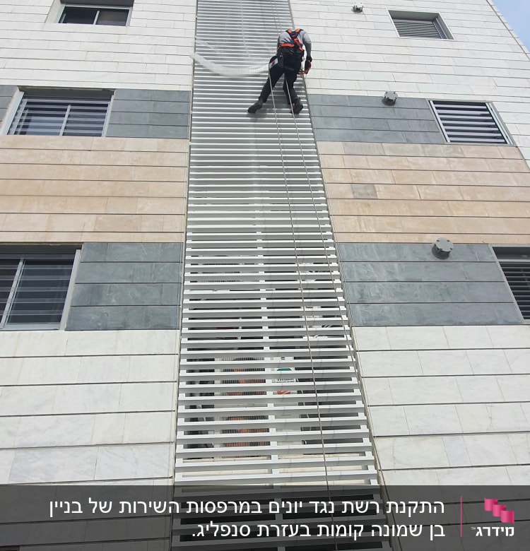 אדם מטפס על בניין עם ציוד בטיחות